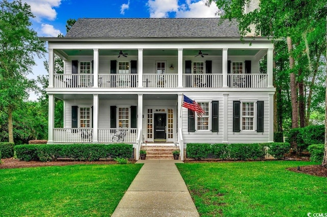 9 Winnowing Way, Pawleys Island, SC 29585 - greek revival house featuring a balcony, a ceiling fan, and a front yard