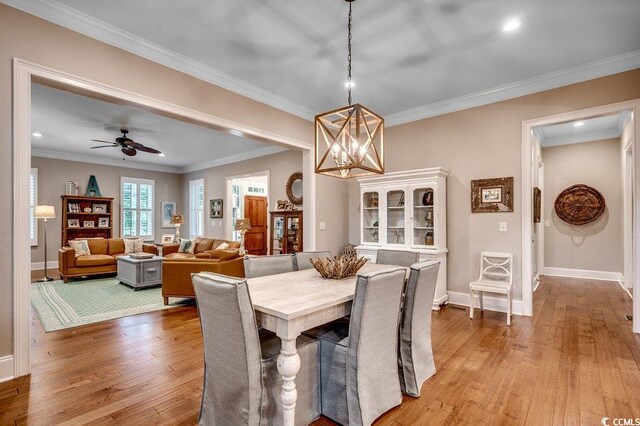 9 Winnowing Way, Pawleys Island, SC 29585 - dining space featuring light wood-type flooring, a chandelier, baseboards, ornamental molding, and a ceiling fan