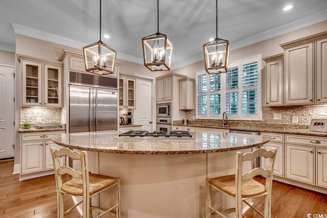 9 Winnowing Way, Pawleys Island, SC 29585 - kitchen featuring built in appliances, backsplash, a sink, glass insert cabinets, and a kitchen breakfast bar