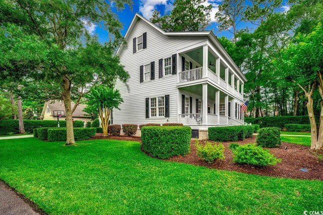 9 Winnowing Way, Pawleys Island, SC 29585 - rear view of house featuring a balcony, a yard, covered porch, and a ceiling fan