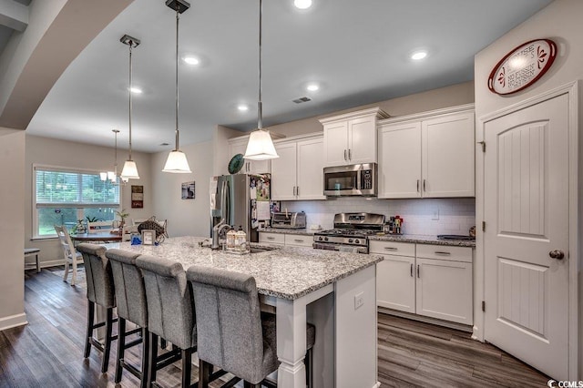 3091 Viceroy Loop, Little River, SC 29566 - kitchen featuring appliances with stainless steel finishes, a sink, dark wood finished floors, a breakfast bar area, and white cabinets