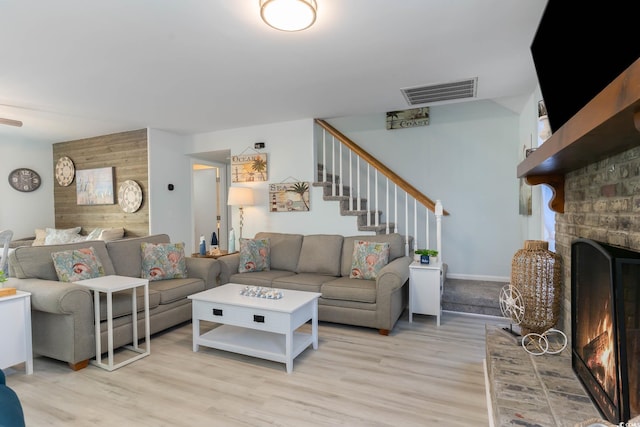 4307 Beverly Ct, North Myrtle Beach, SC 29582 - living room featuring light wood-style floors, a brick fireplace, and stairway