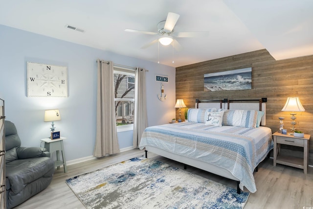 4307 Beverly Ct, North Myrtle Beach, SC 29582 - bedroom with wood walls, an accent wall, baseboards, wood finished floors, and ceiling fan