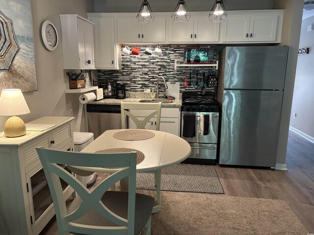 415 Ocean Creek Dr Unit 2117, Myrtle Beach, SC 29572 - kitchen featuring appliances with stainless steel finishes, a sink, wood finished floors, and white cabinetry