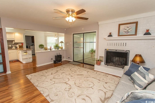 18 Pine Valley Ln, Surfside Beach, SC 29575 - living room with wood finished floors, ceiling fan, and a brick fireplace