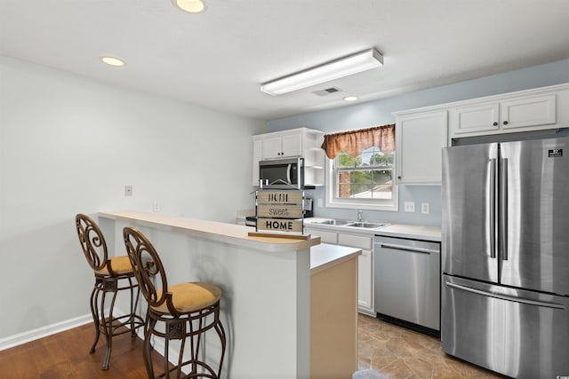 6500 Colonial Dr Unit 2, Myrtle Beach, SC 29572 - kitchen with stainless steel appliances, a kitchen breakfast bar, light countertops, white cabinets, and a peninsula
