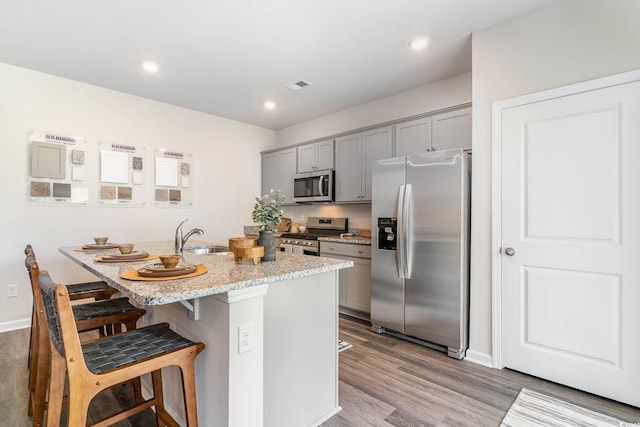 2889 Riverboat Way, Conway, SC 29526 - kitchen with appliances with stainless steel finishes, gray cabinets, a kitchen breakfast bar, wood finished floors, and recessed lighting