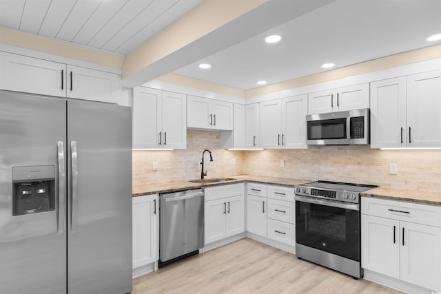 409 14th Ave S, North Myrtle Beach, SC 29582 - kitchen featuring appliances with stainless steel finishes, a sink, white cabinets, light stone countertops, and recessed lighting