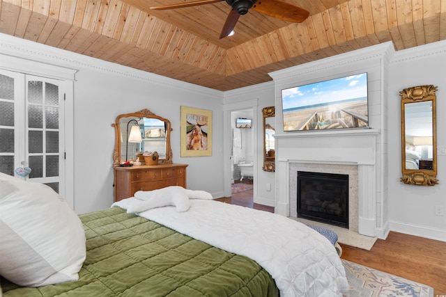 309 Sunset Trl, Myrtle Beach, SC 29577 - bedroom with wooden ceiling, a fireplace with flush hearth, baseboards, ensuite bath, and wood finished floors