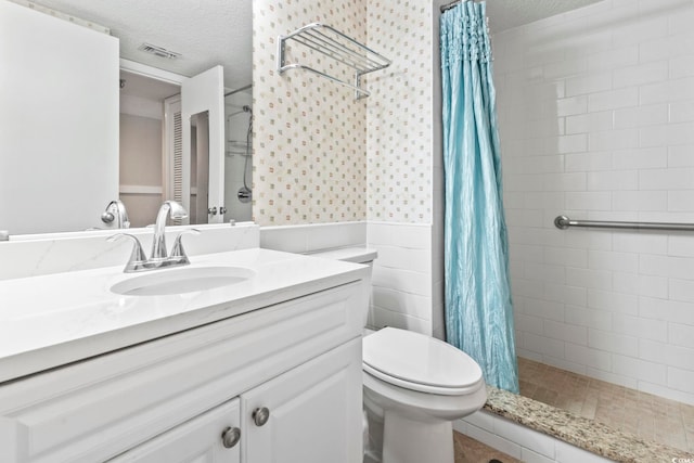 4000 N Ocean Blvd Unit 506, North Myrtle Beach, SC 29582 - full bath with a textured ceiling, vanity, tiled shower, toilet, and a wainscoted wall