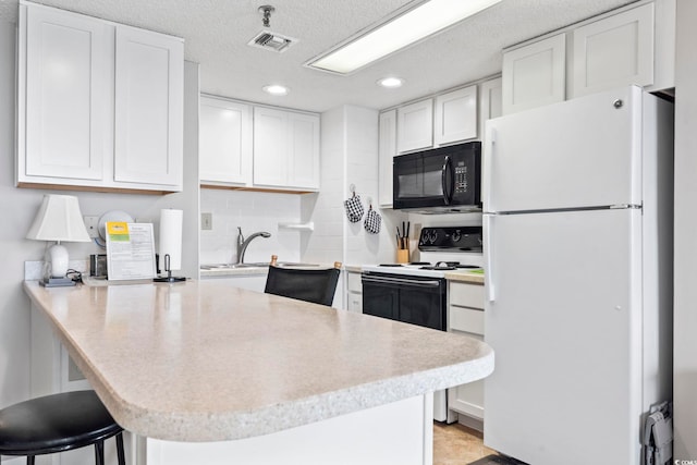 4000 N Ocean Blvd Unit 506, North Myrtle Beach, SC 29582 - kitchen with freestanding refrigerator, black microwave, range with electric cooktop, recessed lighting, and light countertops