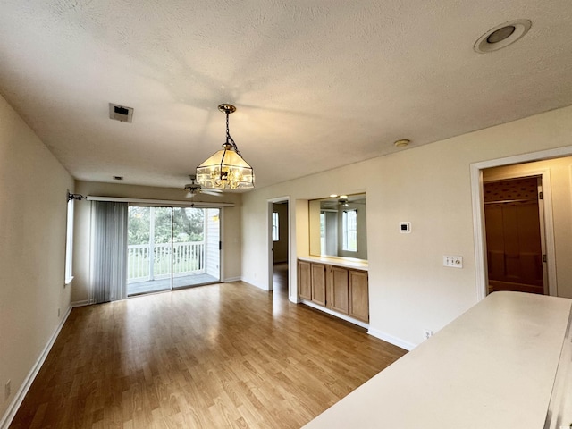 665 Tupelo Ln Unit 17-D, Longs, SC 29568 - unfurnished dining area featuring a chandelier, wood finished floors, baseboards, and a textured ceiling