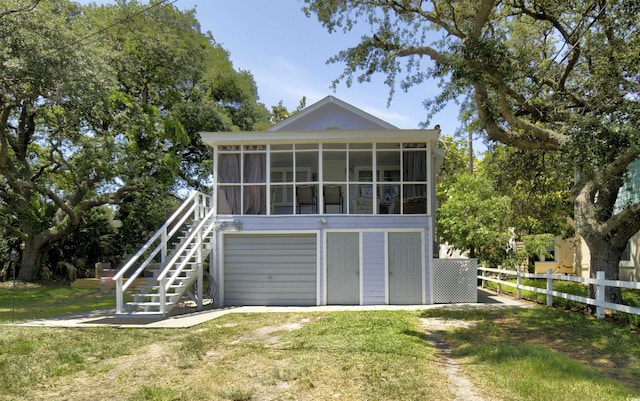 401 17th Ave S, North Myrtle Beach, SC 29582 - rear view of property with a sunroom, driveway, a garage, and stairs
