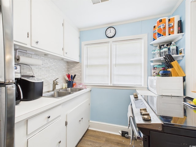401 17th Ave S, North Myrtle Beach, SC 29582 - kitchen featuring a sink, tasteful backsplash, white cabinets, wood finished floors, and baseboards