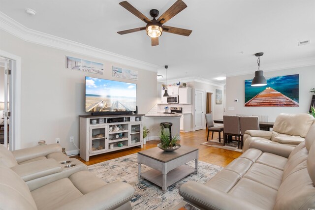 186 Ella Kinley Cir Unit 101, Myrtle Beach, SC 29588 - living area featuring crown molding, ceiling fan, light wood-style floors, and baseboards