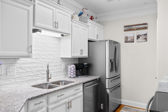 186 Ella Kinley Cir Unit 101, Myrtle Beach, SC 29588 - kitchen with stainless steel appliances, a sink, white cabinets, crown molding, and tasteful backsplash