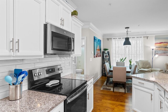 186 Ella Kinley Cir Unit 101, Myrtle Beach, SC 29588 - kitchen with appliances with stainless steel finishes, wood finished floors, white cabinets, crown molding, and tasteful backsplash