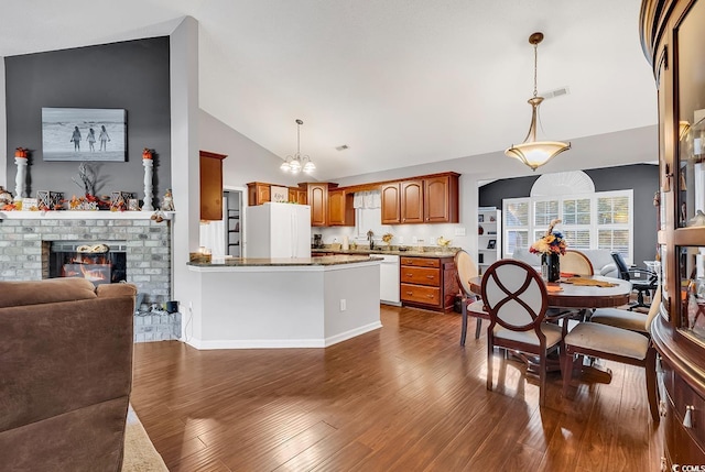 156 Hummingbird Ct, Myrtle Beach, SC 29579 - kitchen with lofted ceiling, white appliances, a chandelier, open floor plan, and a peninsula