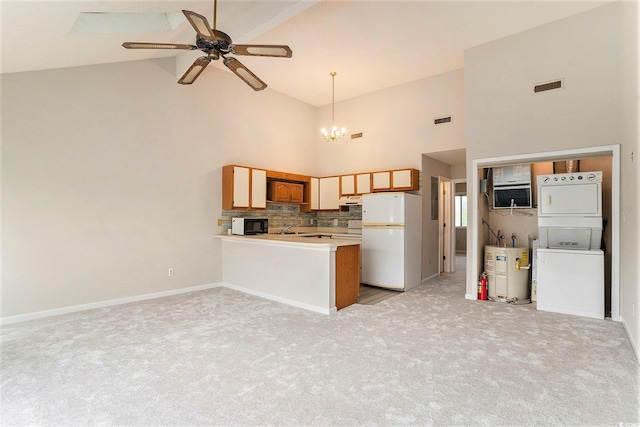 510 Fairwood Lakes Dr Unit 18N, Myrtle Beach, SC 29577 - kitchen featuring stacked washer / drying machine, freestanding refrigerator, high vaulted ceiling, black microwave, and a chandelier