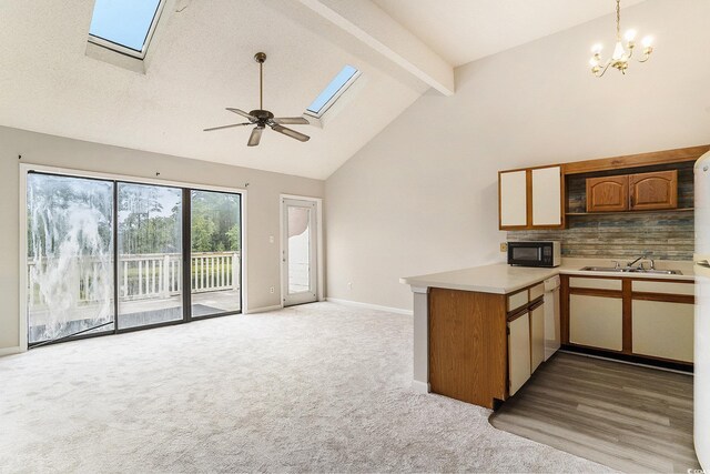 510 Fairwood Lakes Dr Unit 18N, Myrtle Beach, SC 29577 - kitchen featuring black microwave, a skylight, a peninsula, light countertops, and beam ceiling