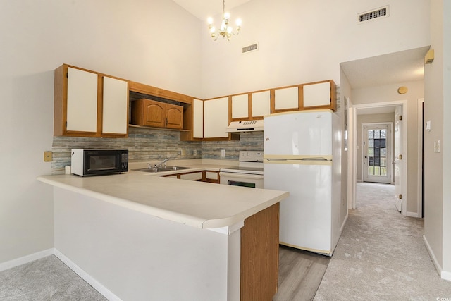 510 Fairwood Lakes Dr Unit 18N, Myrtle Beach, SC 29577 - kitchen with white appliances, under cabinet range hood, light countertops, a sink, and a peninsula