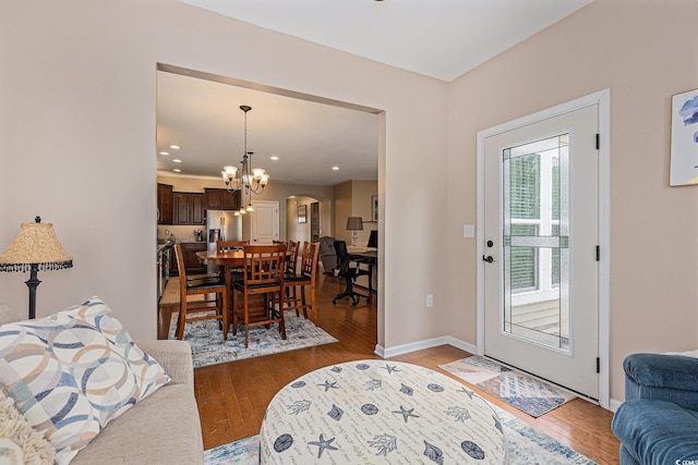 15 Saltwind Loop, Murrells Inlet, SC 29576 - living room featuring light wood-type flooring, a chandelier, arched walkways, and baseboards