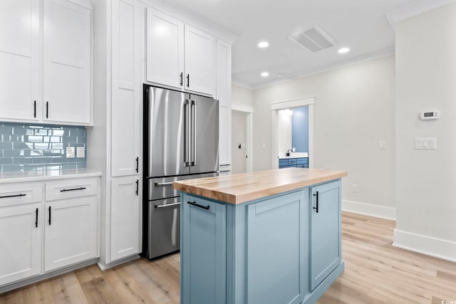4617 Hedrick St, North Myrtle Beach, SC 29582 - kitchen with butcher block countertops, high quality fridge, tasteful backsplash, a kitchen island, and light wood-type flooring