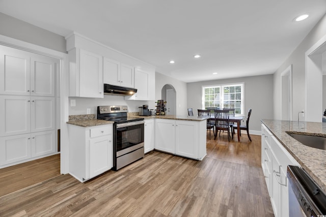 1155 Palmetto St, Georgetown, SC 29440 - kitchen with stainless steel appliances, arched walkways, under cabinet range hood, light wood-style floors, and white cabinets