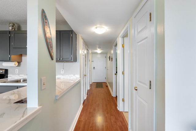 5905 S Kings Hwy Unit 242B, Myrtle Beach, SC 29575 - hallway featuring light wood finished floors, a sink, baseboards, and a textured ceiling