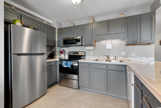 5905 S Kings Hwy Unit 242B, Myrtle Beach, SC 29575 - kitchen with appliances with stainless steel finishes, a sink, light countertops, a textured ceiling, and light tile patterned flooring