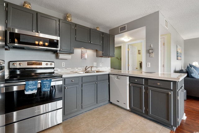 5905 S Kings Hwy Unit 242B, Myrtle Beach, SC 29575 - kitchen with stainless steel appliances, a peninsula, a sink, light countertops, and a textured ceiling