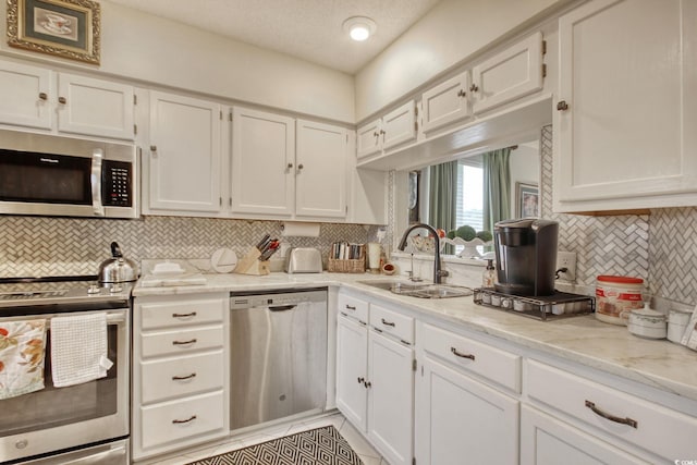 4396 Baldwin Ave Unit 1, Little River, SC 29566 - kitchen featuring appliances with stainless steel finishes, a sink, white cabinets, decorative backsplash, and a textured ceiling