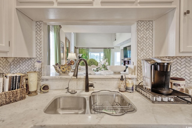 4396 Baldwin Ave Unit 1, Little River, SC 29566 - kitchen featuring decorative backsplash, a sink, white cabinetry, and light stone countertops
