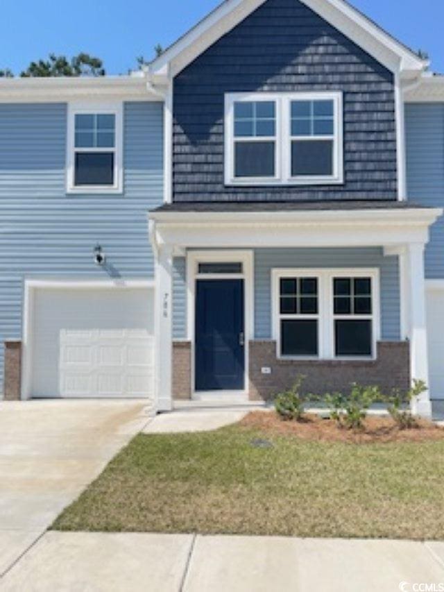 786 NW Palm Frond Way Unit 51, Calabash, NC 28467 - view of front of home with a garage, concrete driveway, a front lawn, and brick siding