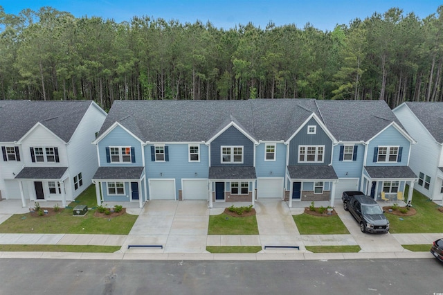 786 NW Palm Frond Way Unit 51, Calabash, NC 28467 - townhome / multi-family property with driveway, an attached garage, a wooded view, a shingled roof, and a front yard