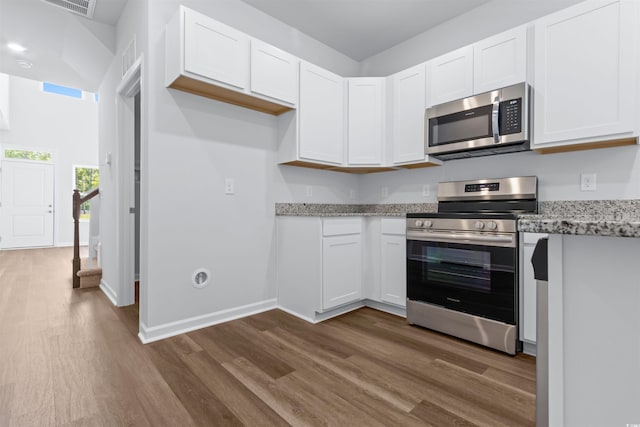 786 NW Palm Frond Way Unit 51, Calabash, NC 28467 - kitchen featuring stainless steel appliances, dark wood-style floors, white cabinetry, and light stone counters