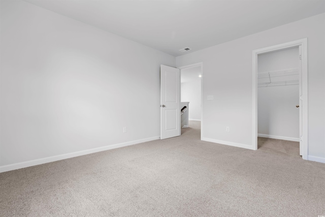 786 NW Palm Frond Way Unit 51, Calabash, NC 28467 - unfurnished bedroom with light colored carpet, baseboards, a spacious closet, and a closet