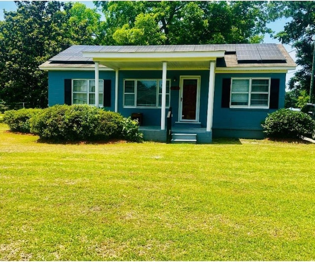 8 Raymond St, Andrews, SC 29510 - view of front of home featuring roof mounted solar panels, a front yard, and a porch