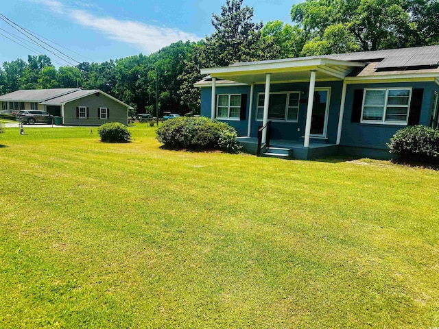 8 Raymond St, Andrews, SC 29510 - view of front facade featuring covered porch, a front yard, and solar panels