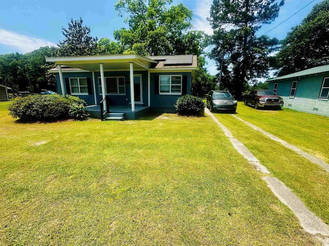 8 Raymond St, Andrews, SC 29510 - view of front of house featuring covered porch, solar panels, dirt driveway, and a front lawn
