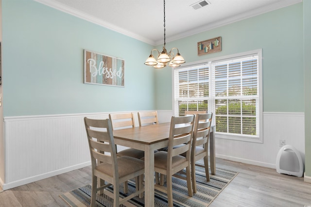 411 Mahogany Dr Unit 101, Murrells Inlet, SC 29576 - dining space featuring wainscoting, light wood-style floors, ornamental molding, a chandelier, and baseboards