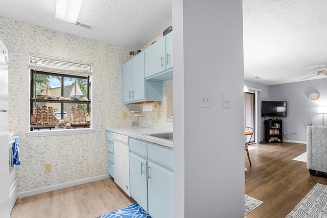 614 15th Ave S Unit 41, Surfside Beach, SC 29575 - kitchen featuring blue cabinets, light wood-type flooring, wallpapered walls, white dishwasher, and a textured ceiling