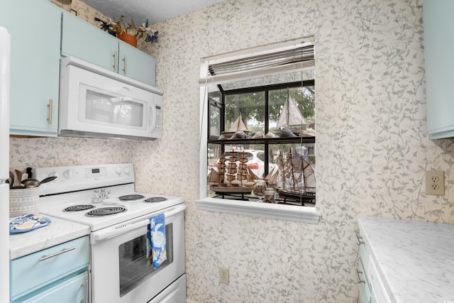 614 15th Ave S Unit 41, Surfside Beach, SC 29575 - kitchen featuring white appliances, wallpapered walls, blue cabinetry, and light countertops