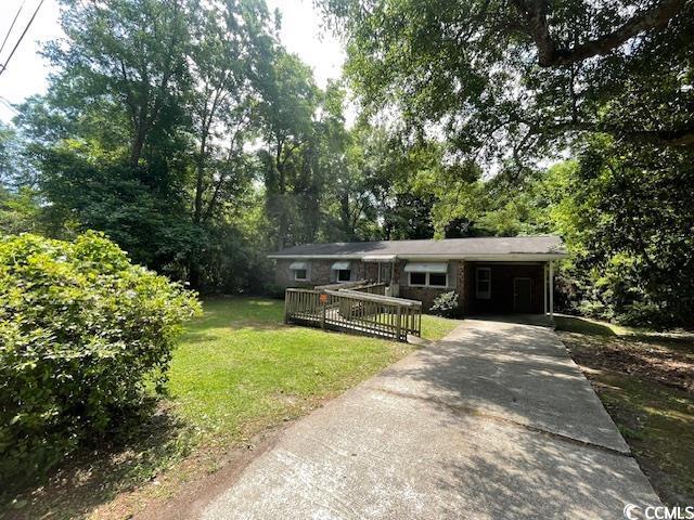 41 Harmon St, Hemingway, SC 29554 - single story home with a front yard, driveway, a carport, and view of scattered trees
