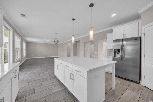 5621 Camilla Ct, Myrtle Beach, SC 29579 - kitchen featuring stainless steel fridge with ice dispenser, ornamental molding, light countertops, a kitchen island, and baseboards