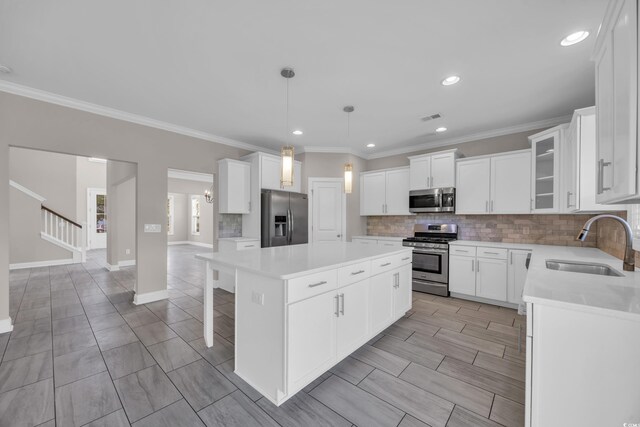 5621 Camilla Ct, Myrtle Beach, SC 29579 - kitchen featuring stainless steel appliances, a sink, a kitchen island, decorative backsplash, and light countertops