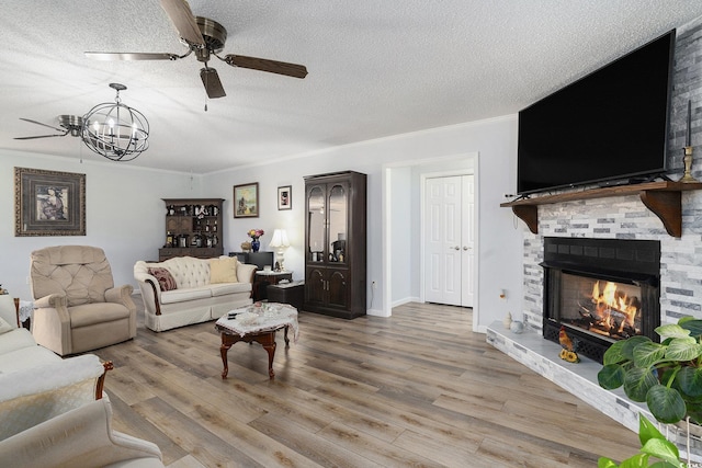 2981 Victor Rd, Longs, SC 29568 - living room with a ceiling fan, light wood-style floors, a textured ceiling, a chandelier, and a large fireplace