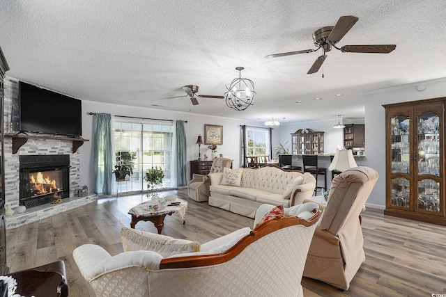 2981 Victor Rd, Longs, SC 29568 - living room with a ceiling fan, a textured ceiling, a chandelier, a fireplace, and wood finished floors