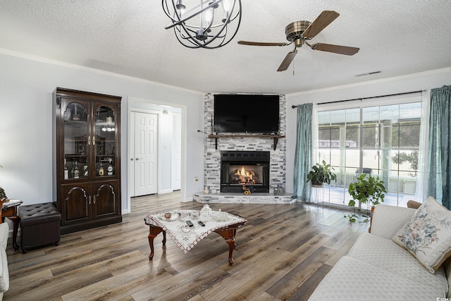 2981 Victor Rd, Longs, SC 29568 - living room featuring wood finished floors, crown molding, a textured ceiling, a ceiling fan, and a brick fireplace