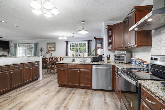 2981 Victor Rd, Longs, SC 29568 - kitchen featuring appliances with stainless steel finishes, wall chimney range hood, a sink, a chandelier, and a textured ceiling